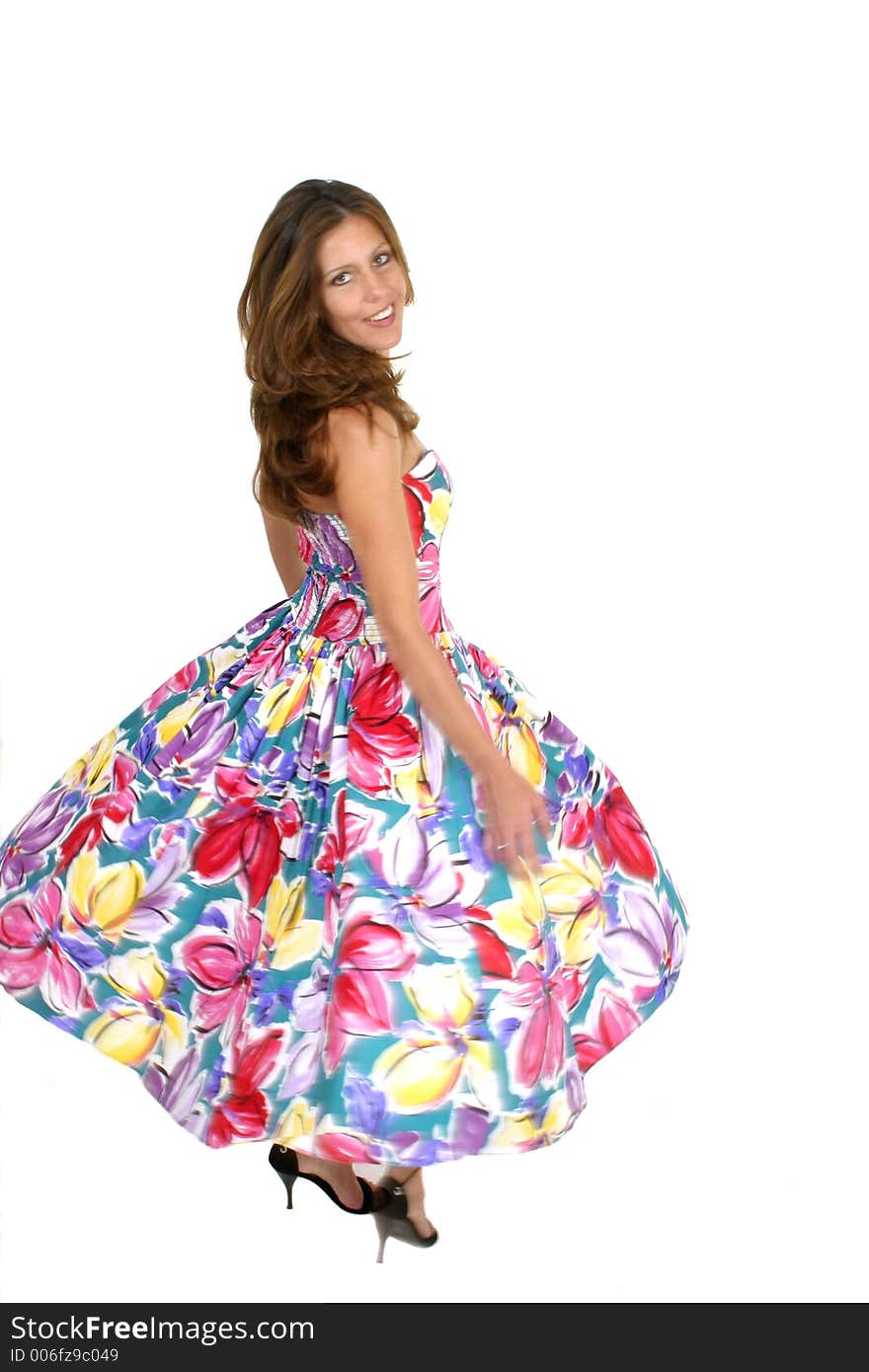 Beautiful brunette woman turning and spinning in a brightly colored dress. Some motion blur. Isolated on white. Beautiful brunette woman turning and spinning in a brightly colored dress. Some motion blur. Isolated on white.