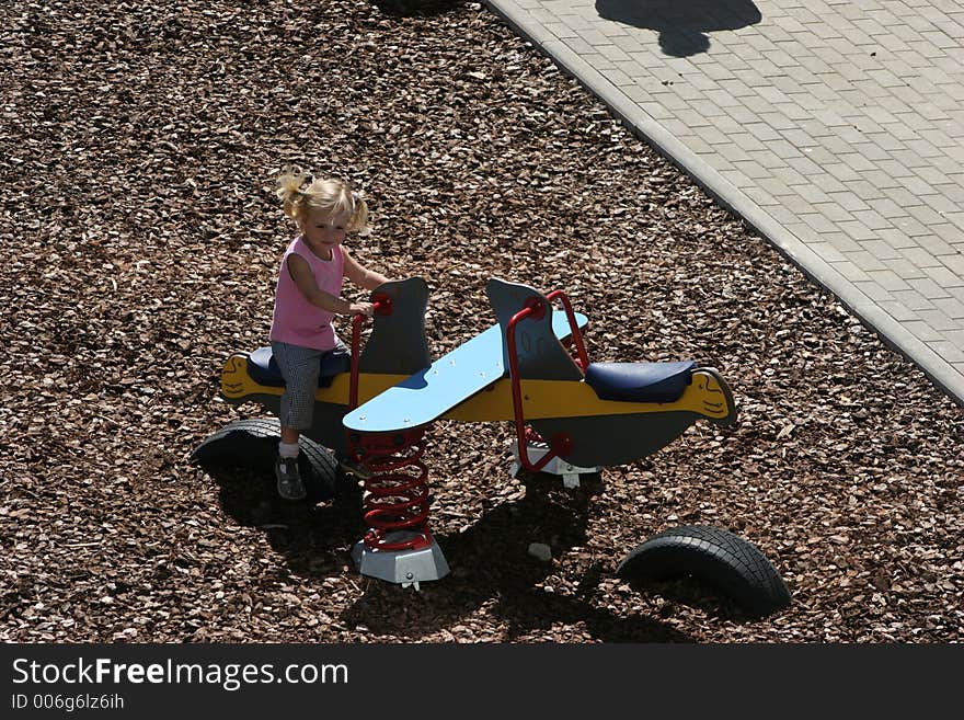 The girl playing on a children's playground. The girl playing on a children's playground