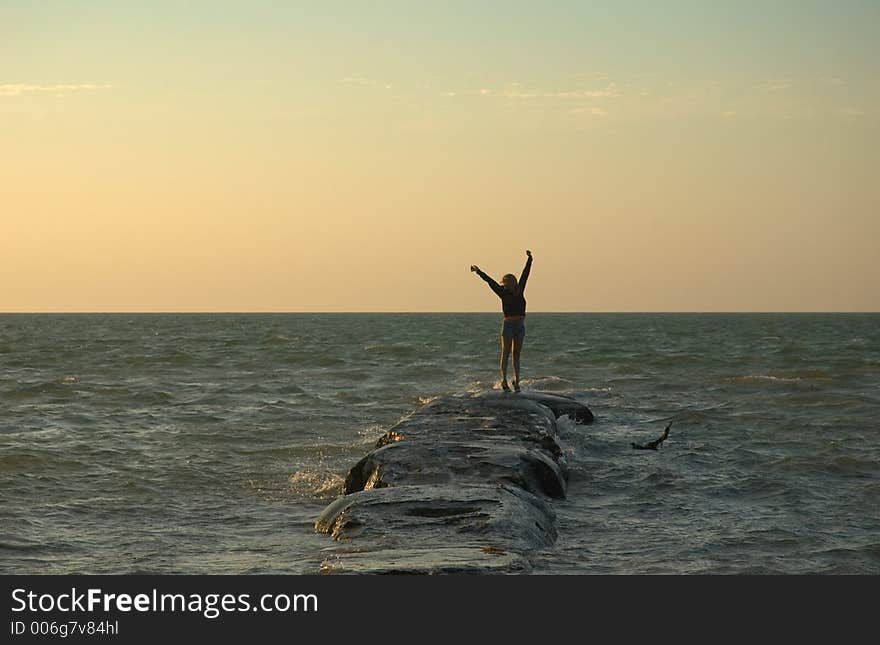 Girl jumping on a rock at sunset in Holbox, Caribbean, Mexico