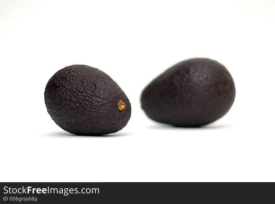 Two avocados against white