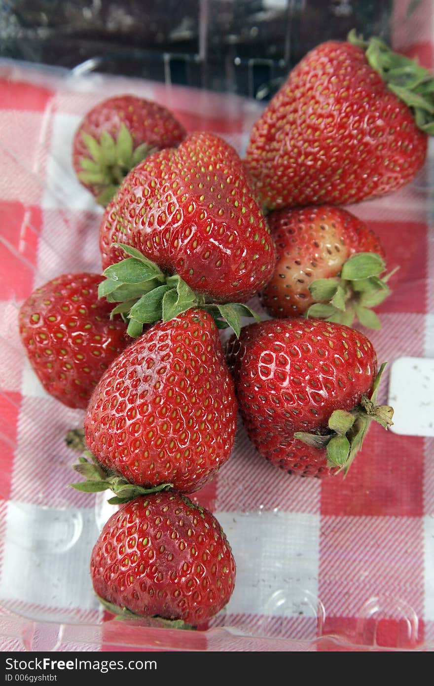 Fresh strawberries in plastic on a picnic table