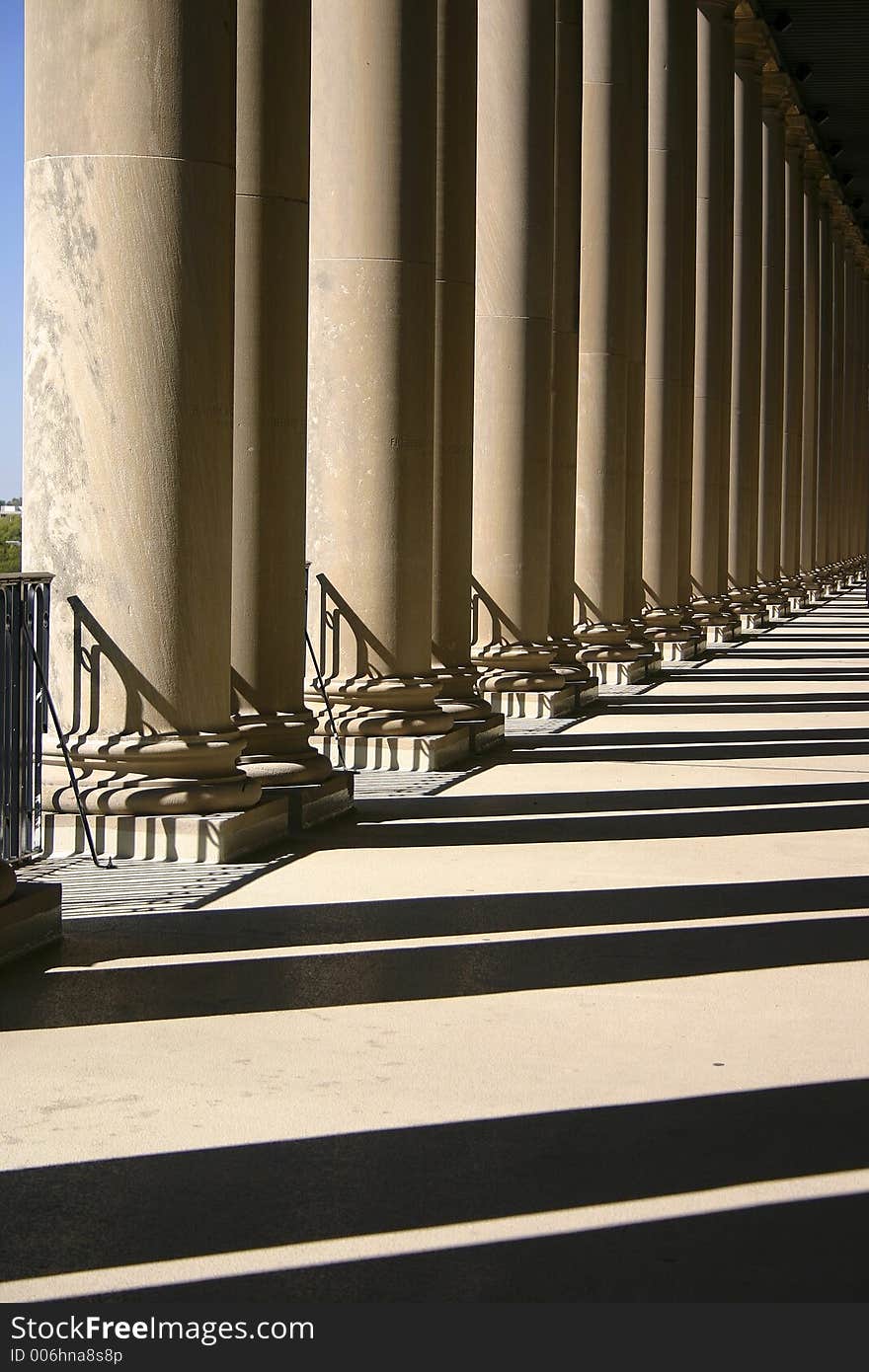 The pillars of a building cast lines of shadows