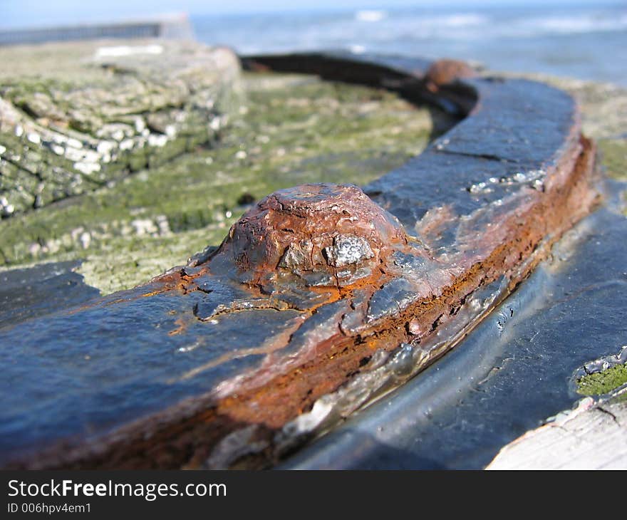 Macro shot of rusting flaking ironwork, with very old decaying paint. Substrate is old worn wood which is itself decaying. Macro shot of rusting flaking ironwork, with very old decaying paint. Substrate is old worn wood which is itself decaying.