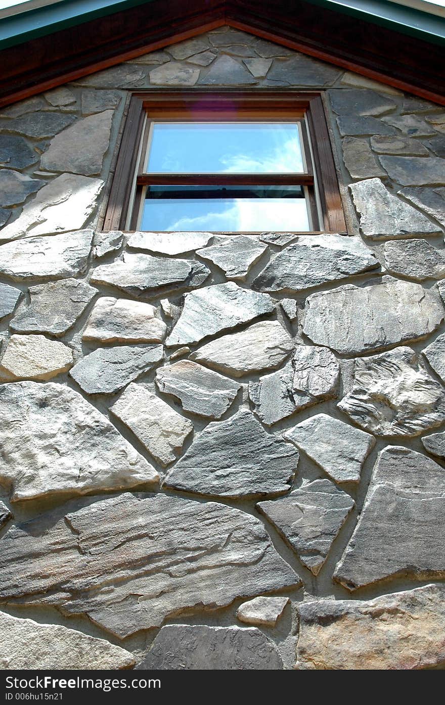 Looking up rock wall at window with sky reflection. Looking up rock wall at window with sky reflection.