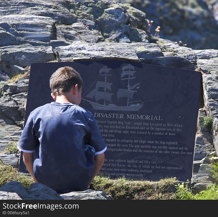 Young child reading memorial stone