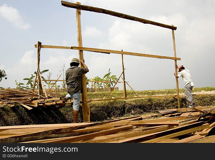 Men building temporary shelter on a rice paddy in rural Philippines. Men building temporary shelter on a rice paddy in rural Philippines