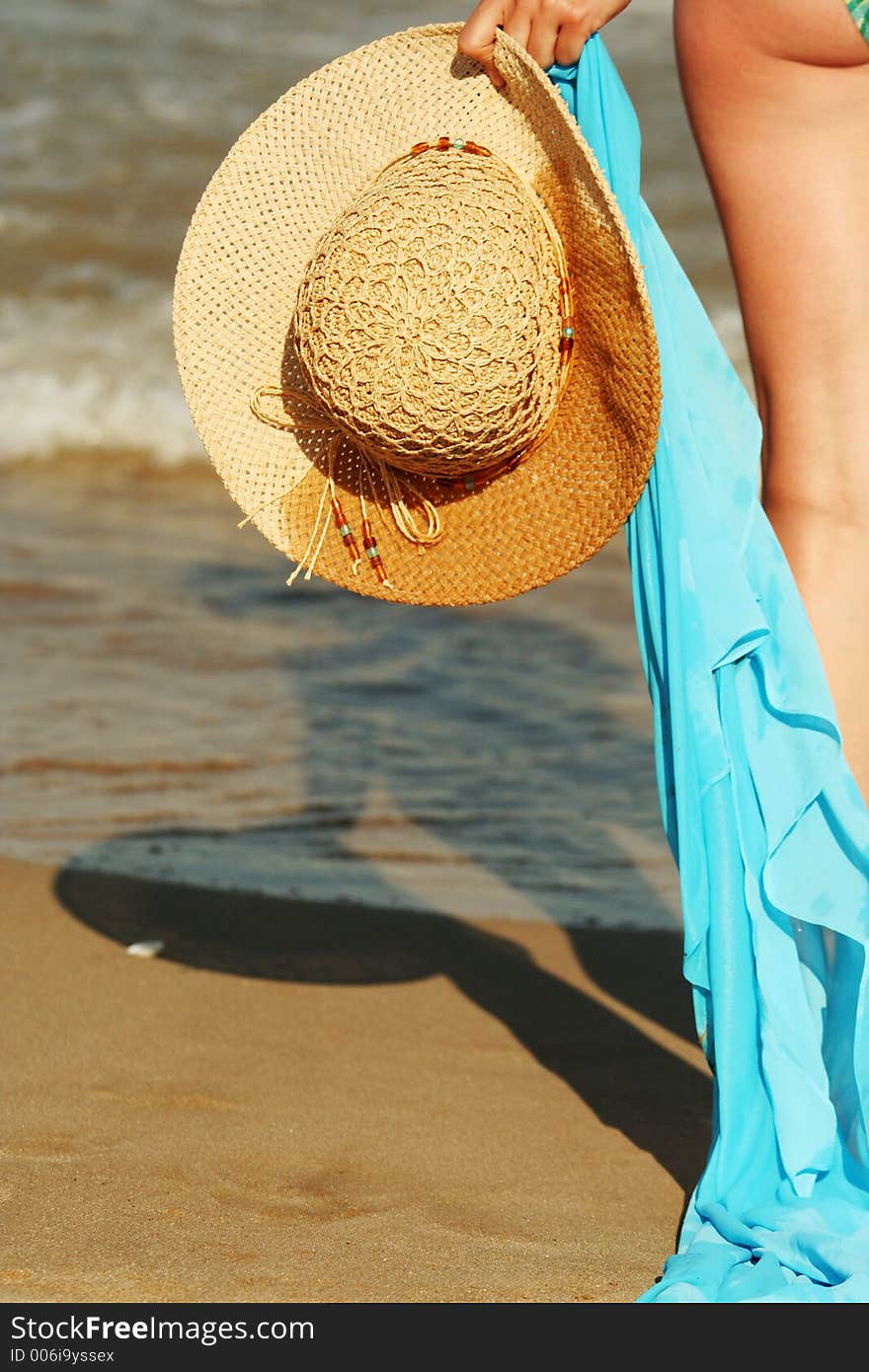 Detail of a hat and a scarf hold by a beautiful women, marvelous sunny beach. Detail of a hat and a scarf hold by a beautiful women, marvelous sunny beach.