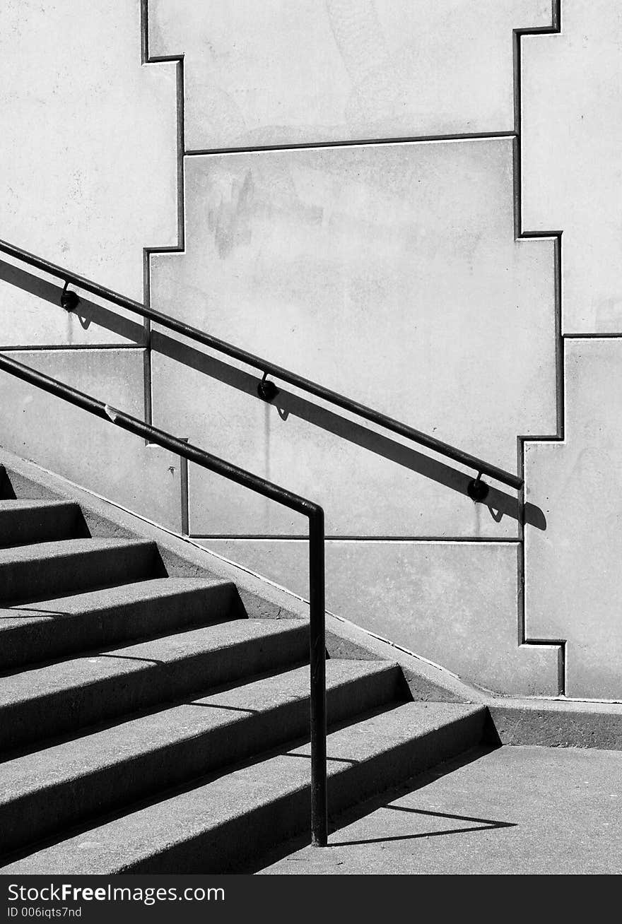 Outdoor stairs rising past interlocking stone blocks. Outdoor stairs rising past interlocking stone blocks