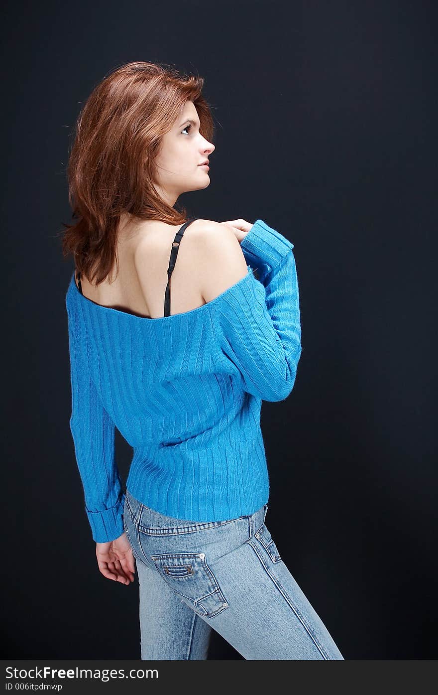 girl,in blue jeans and blue blouse posing, on black background. girl,in blue jeans and blue blouse posing, on black background