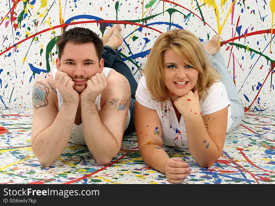 Young casual couple; splashed painted background. Young casual couple; splashed painted background