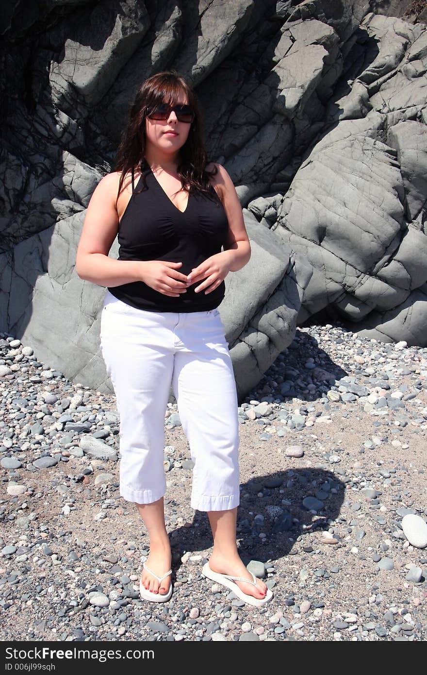 Young woman on Beach with glasses and pants on