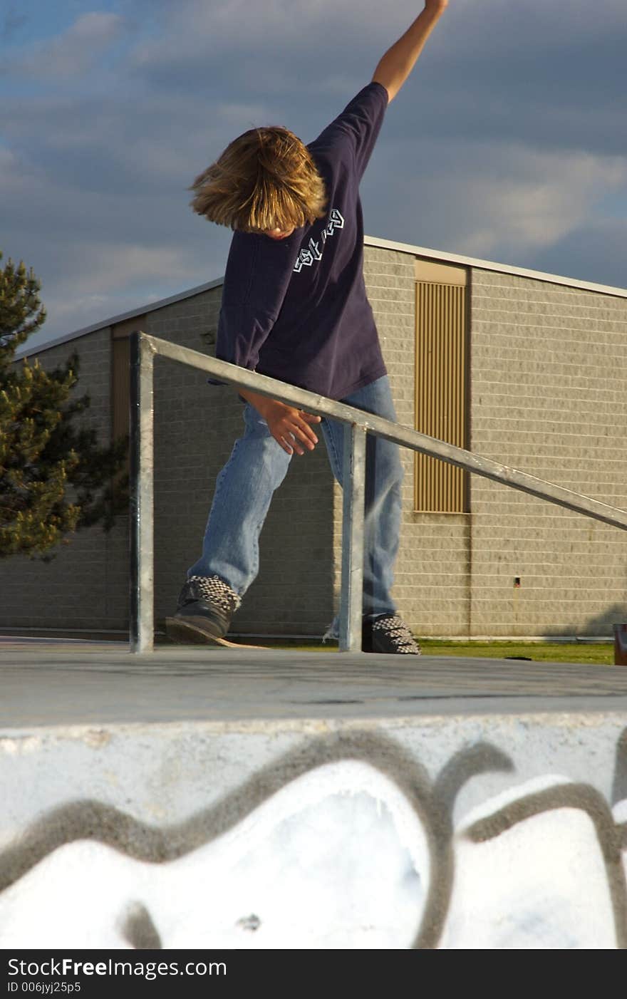 A young boy skateboarding up a ramp at a skate park. A young boy skateboarding up a ramp at a skate park