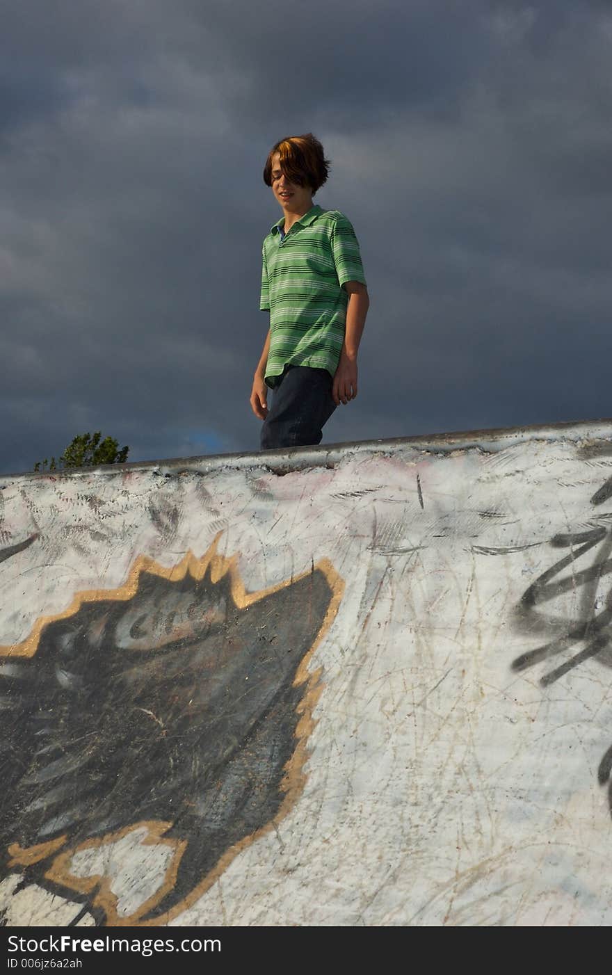 A young boy skateboarding down a ramp at a skate park. A young boy skateboarding down a ramp at a skate park