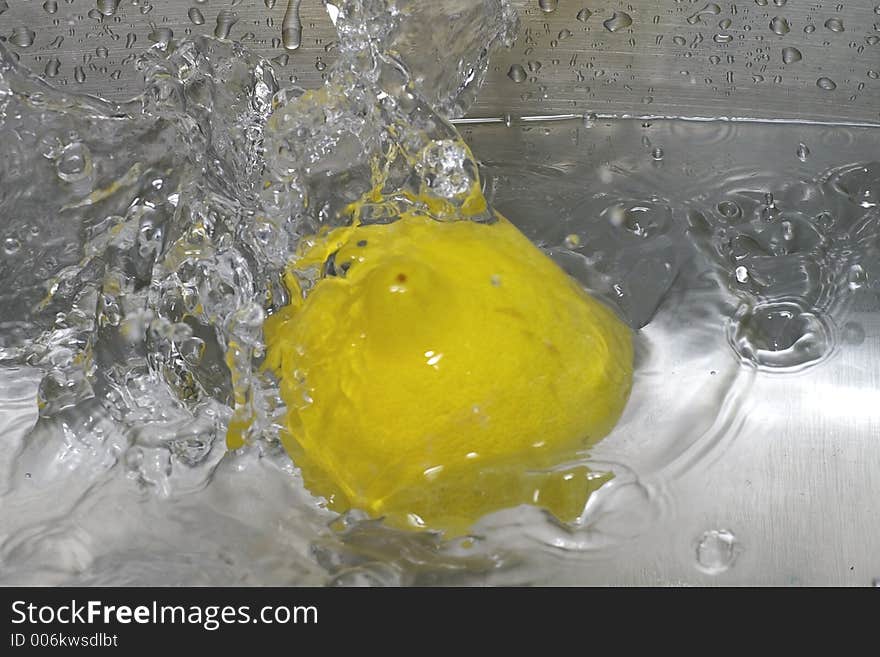 Closeup of a lemon spashing into a pool of water. Closeup of a lemon spashing into a pool of water