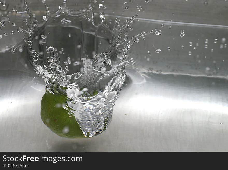 Closeup of a lime spashing into a pool of water. Closeup of a lime spashing into a pool of water