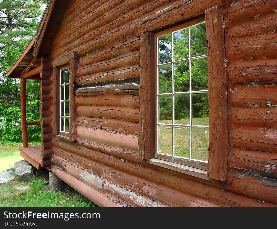 The windows of a log cabin reflecting the scenery. The windows of a log cabin reflecting the scenery