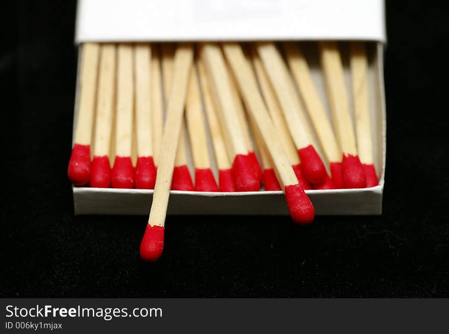 Closeup of Red Tipped wooden match sticks in a match box