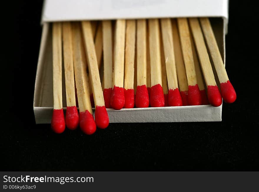 Closeup of Red Tipped wooden match sticks in a match box