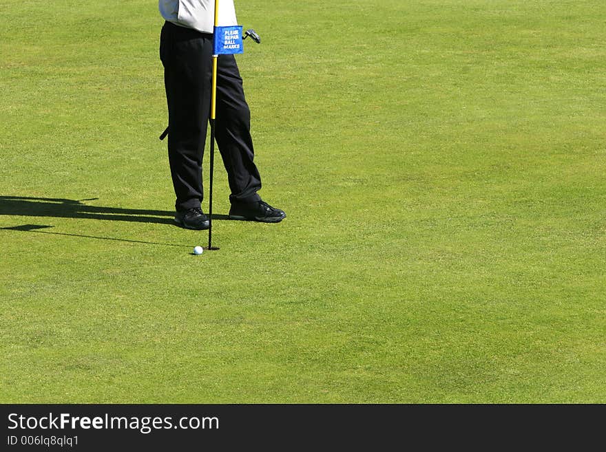 Golfcourse on a sunny day, golfers playing on the greens. Golfcourse on a sunny day, golfers playing on the greens