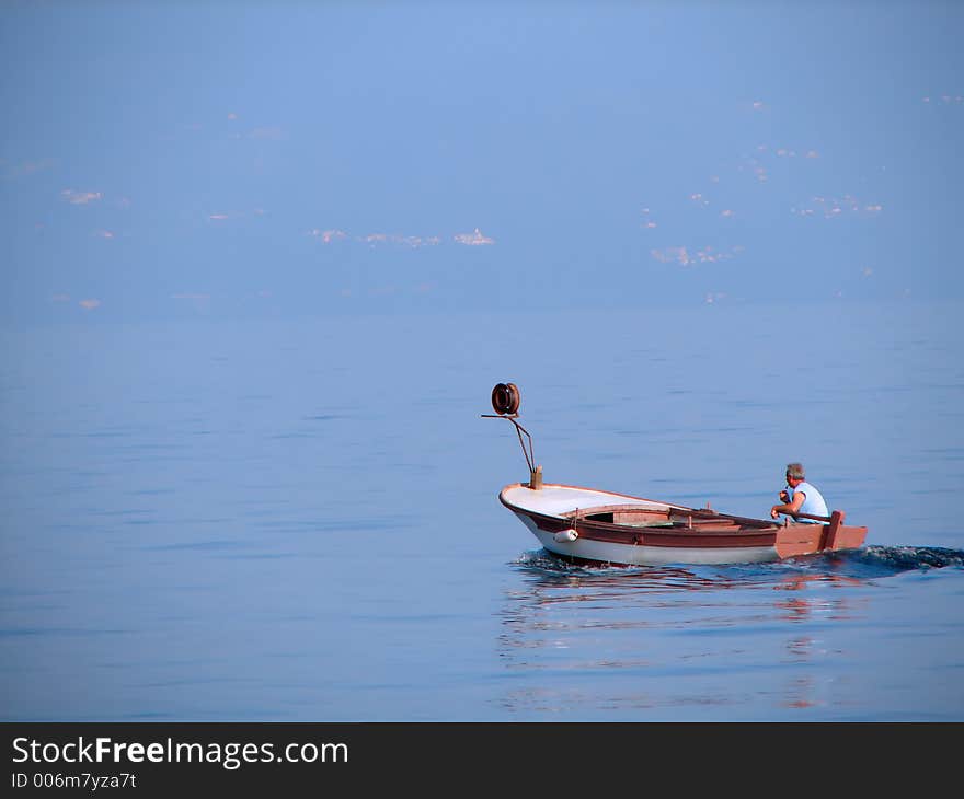 Fisherman in a small boat on a sea