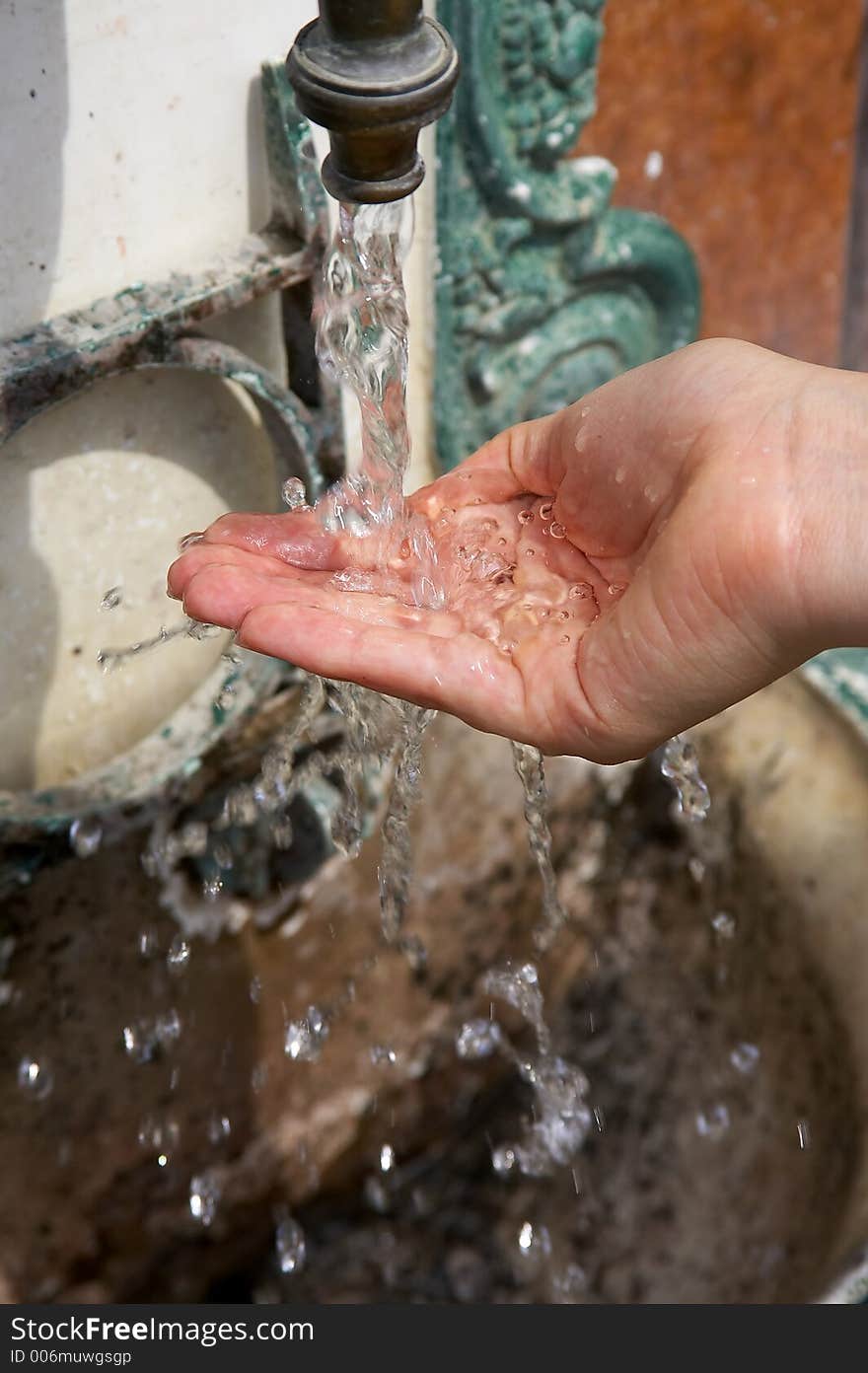 Hand under the stream of water from a fountain