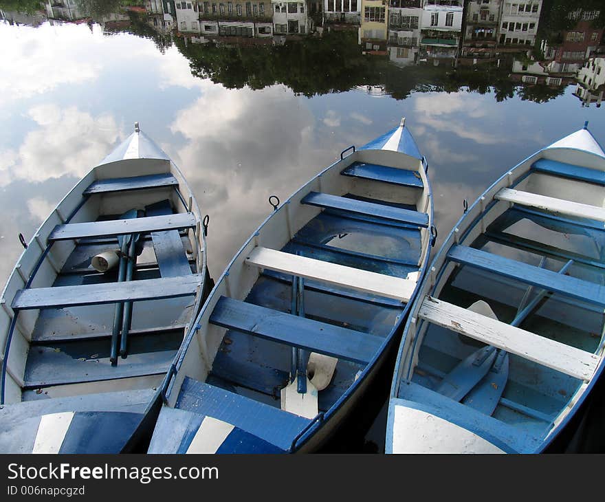 Three blue boats in a river. Three blue boats in a river