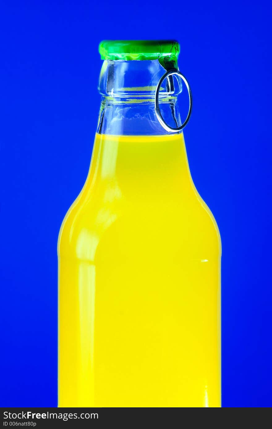 Glowing bottle of yellow drink on blue background. Glowing bottle of yellow drink on blue background