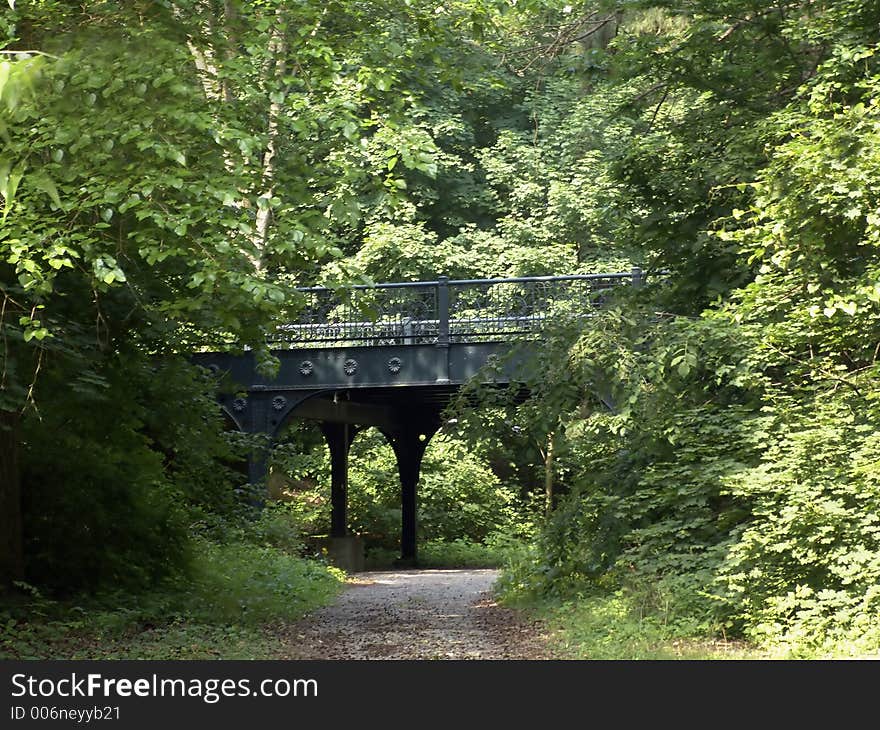 A very old steel bridge seemingly nestled in the trees. A very old steel bridge seemingly nestled in the trees.