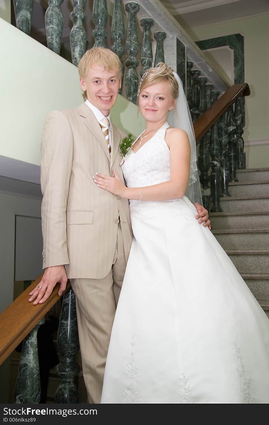 Newlywedses stand on stairway. Newlywedses stand on stairway