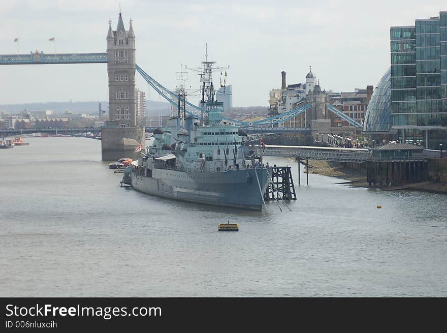 HMS Belfast Battleship on Thames River in front of London Bridge and other buildings in the city of London. HMS Belfast Battleship on Thames River in front of London Bridge and other buildings in the city of London.