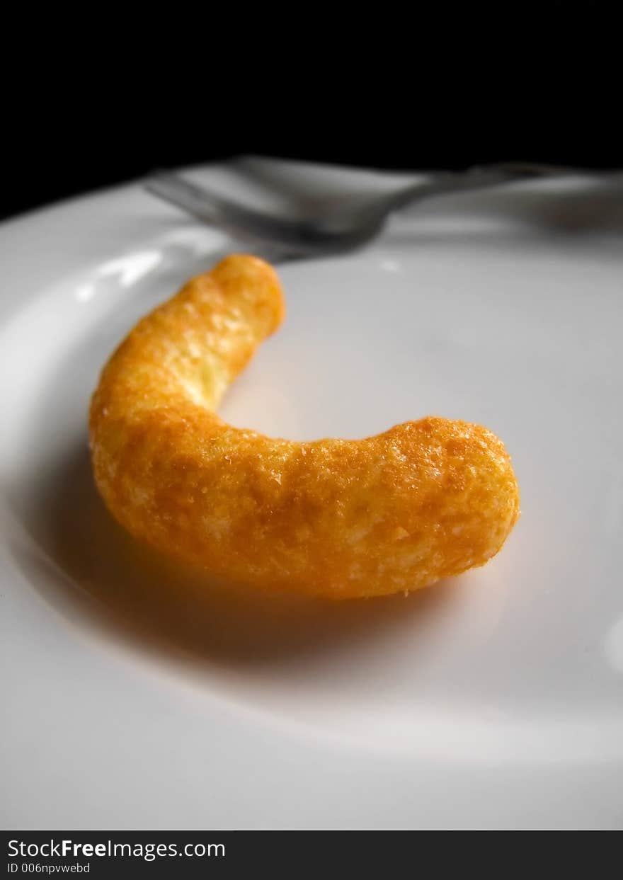 A bright orange cheese puff on a plate