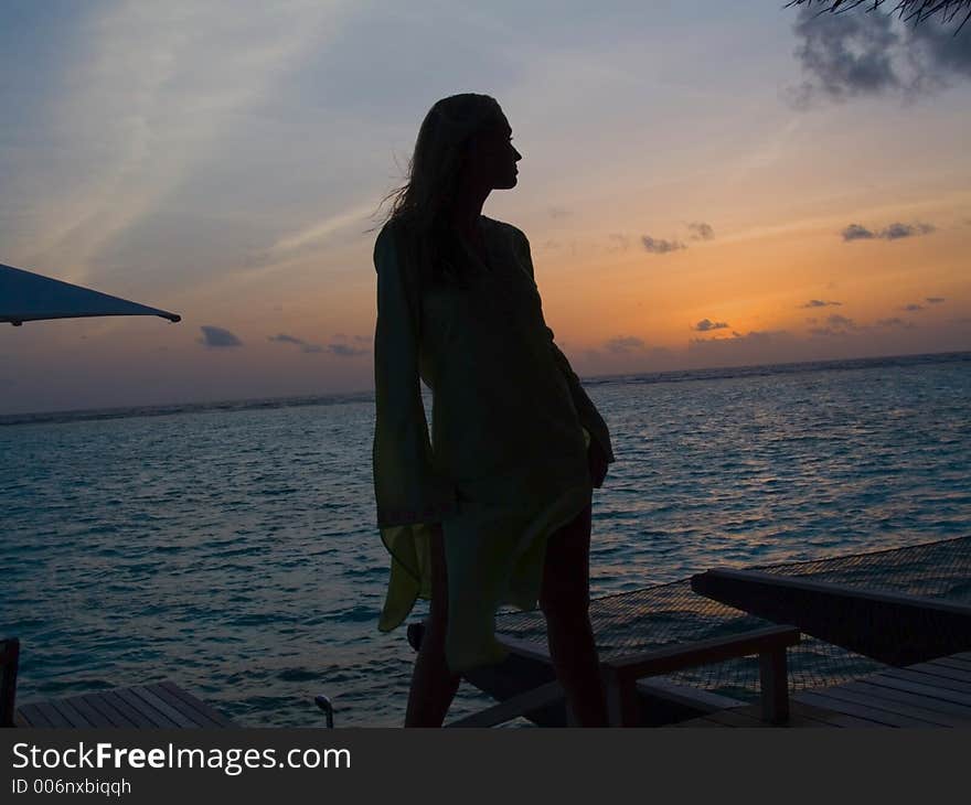 A shot of this beautiful model in silhouette with a sunset in the background and the tropical ocean waters of the Maldives. A shot of this beautiful model in silhouette with a sunset in the background and the tropical ocean waters of the Maldives