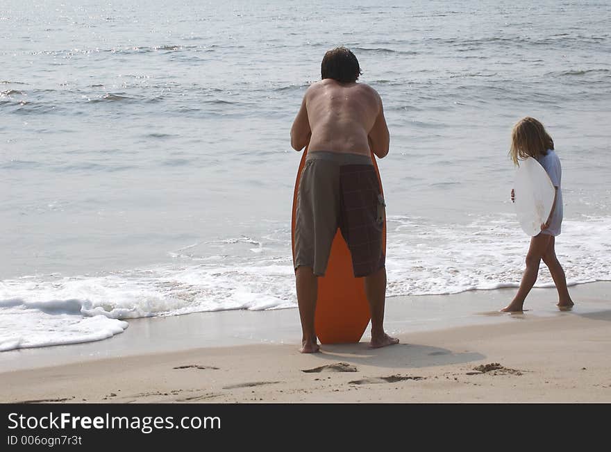 Skimboarders on beach waiting for the waves. Skimboarders on beach waiting for the waves