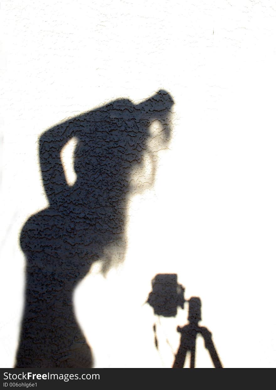 Shadow against stucco wall ~ female form and camera on tri-pod. Shadow against stucco wall ~ female form and camera on tri-pod