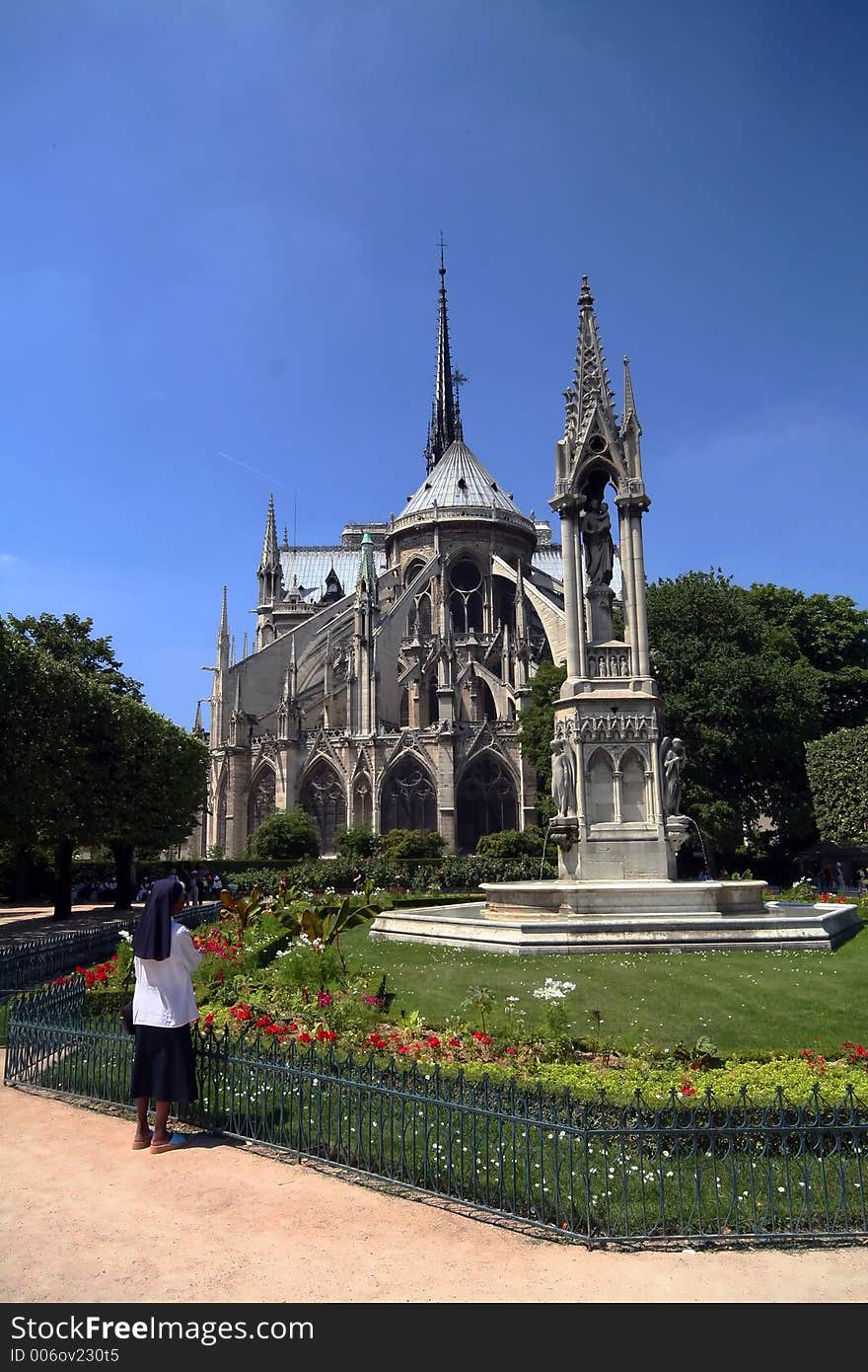 Religious woman praying in front of Notre Dame cathedral