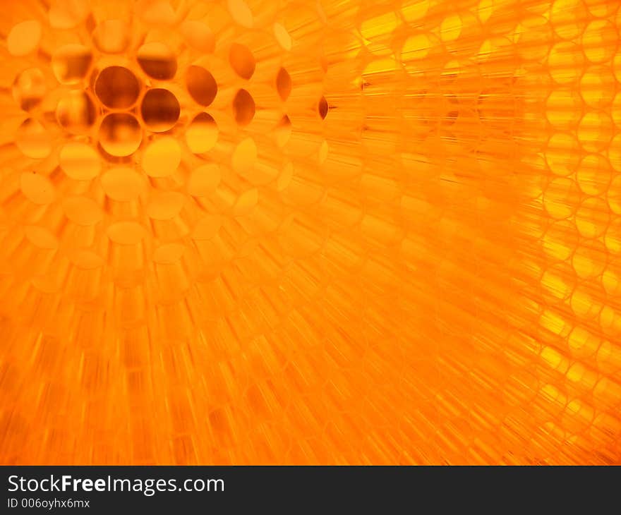 A wall made of small pieces of orange straw that defracts light as people walk along it, taken at the IIT student center