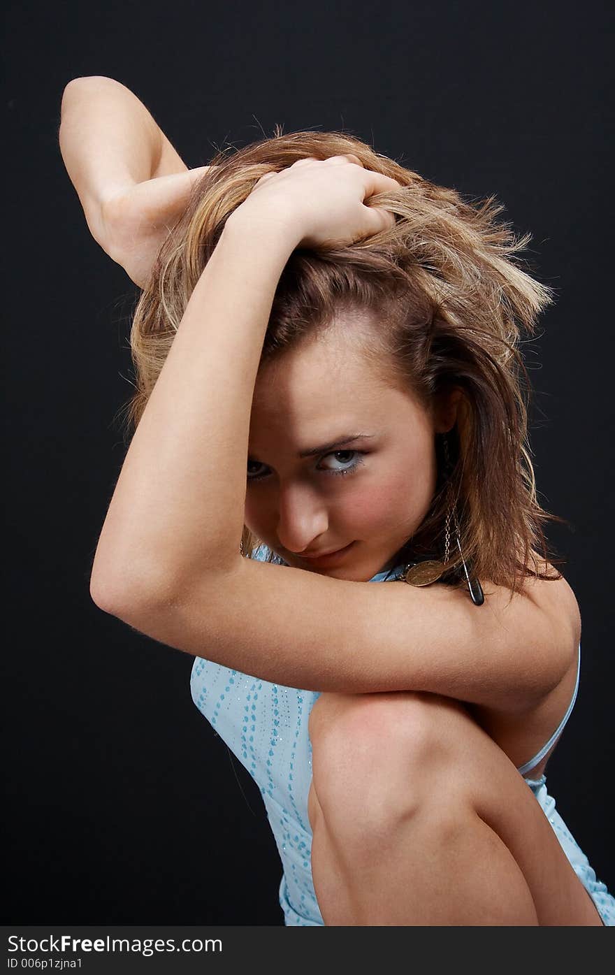 Sexy blonde in blue dress, on black background