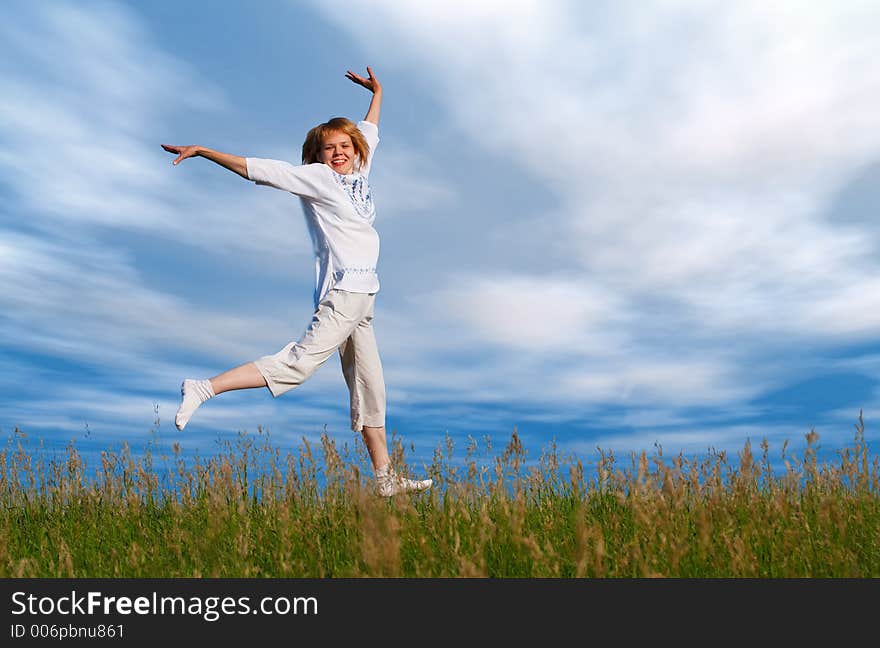 Jumping girl under clouds