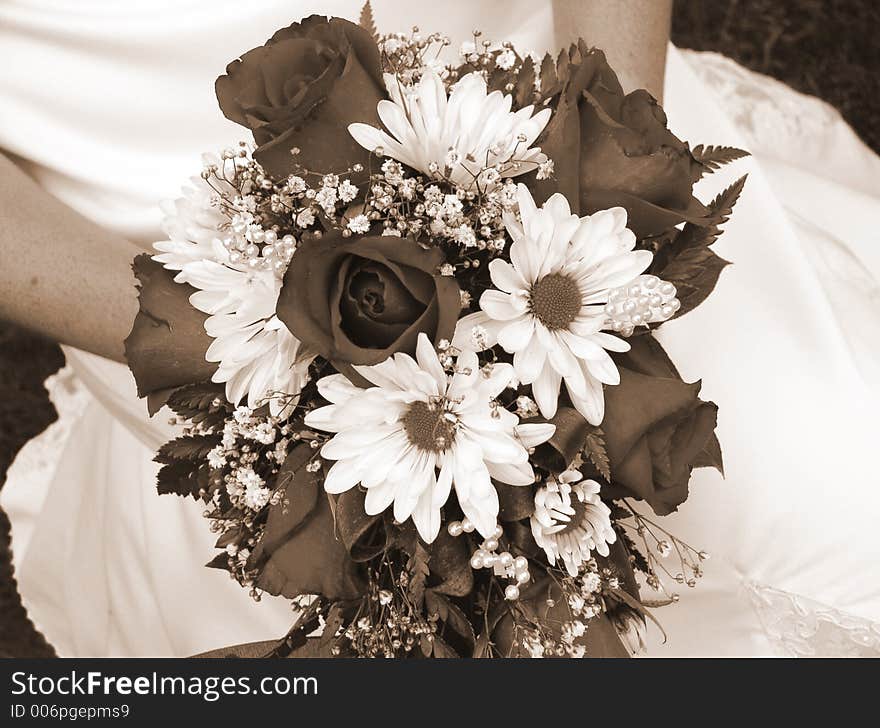 Bride holding her wedding bouquet against her dress