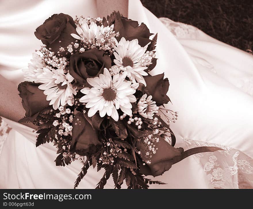 Bride holding her wedding bouquet against her dress