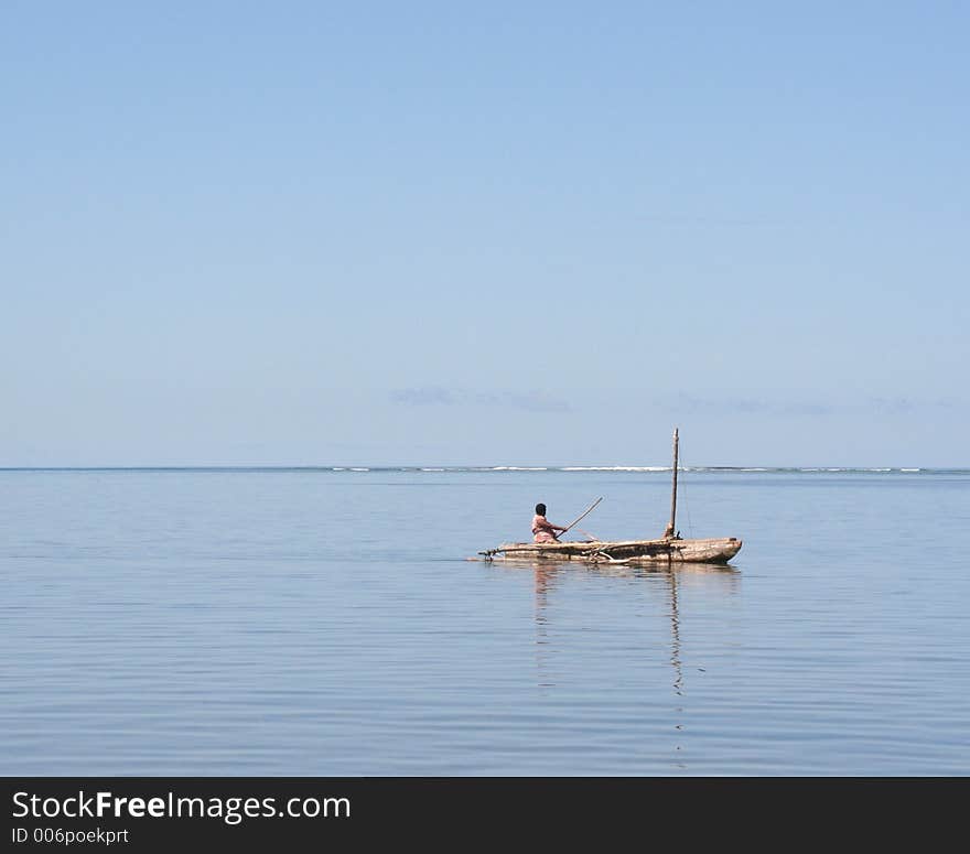 Pacific islander paddling a canoe across open sea to get to work on another island. In the evening they sail back using the prevailing wind. Pacific islander paddling a canoe across open sea to get to work on another island. In the evening they sail back using the prevailing wind.