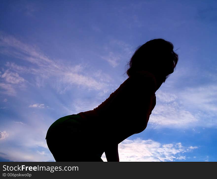 Feminine silhouette on background sky. Feminine silhouette on background sky