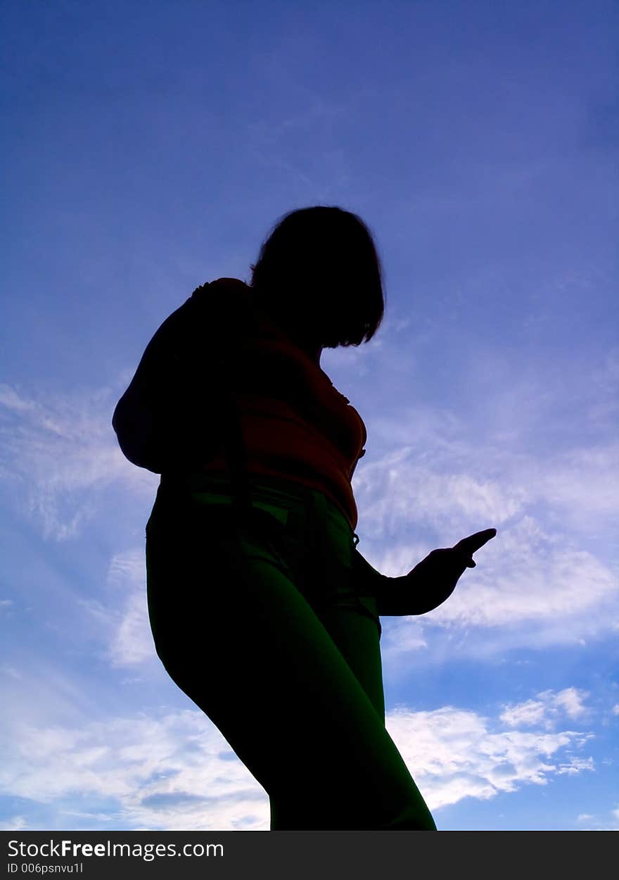 Feminine silhouette on background sky