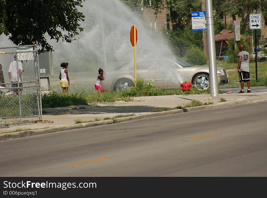 Kids playing in an open hydrant in Chicago.  July 2006. Kids playing in an open hydrant in Chicago.  July 2006.