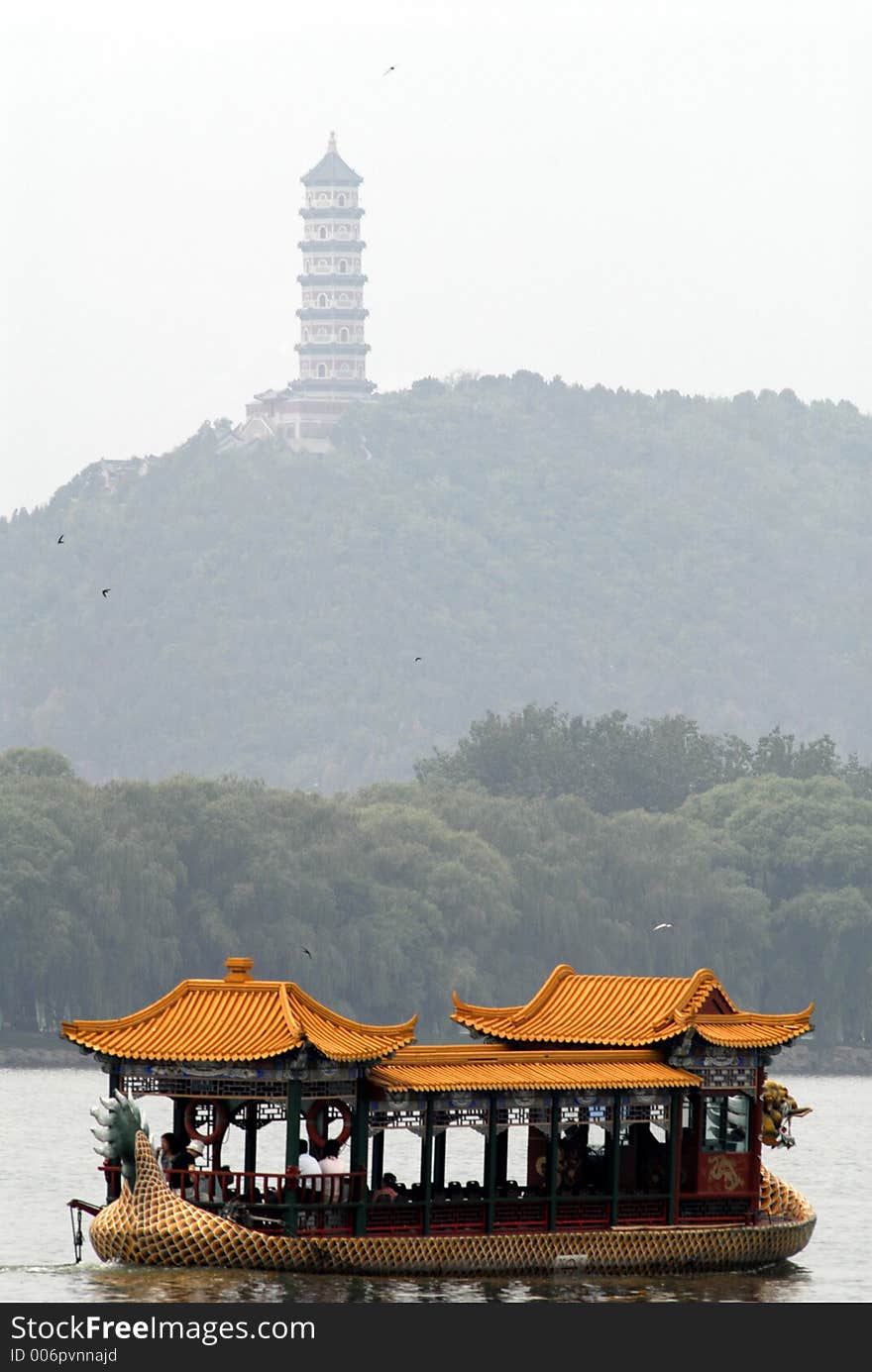 A dragon boat with an ancient tower in the background