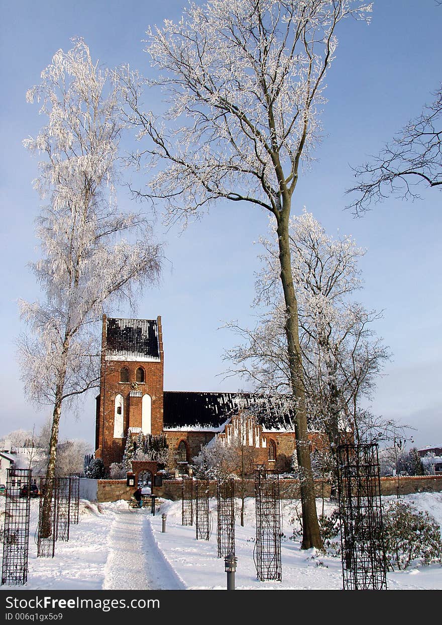 Church  in denmark a sunny winter day with a frozen tree in the  foreground