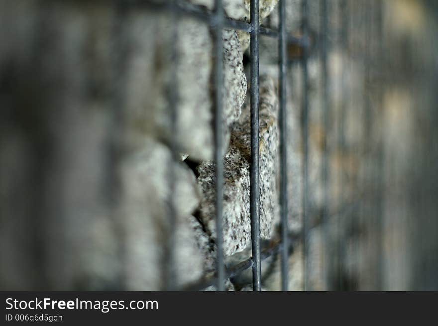 Stones imprisoned in a steelcage; shallow DOF. Stones imprisoned in a steelcage; shallow DOF