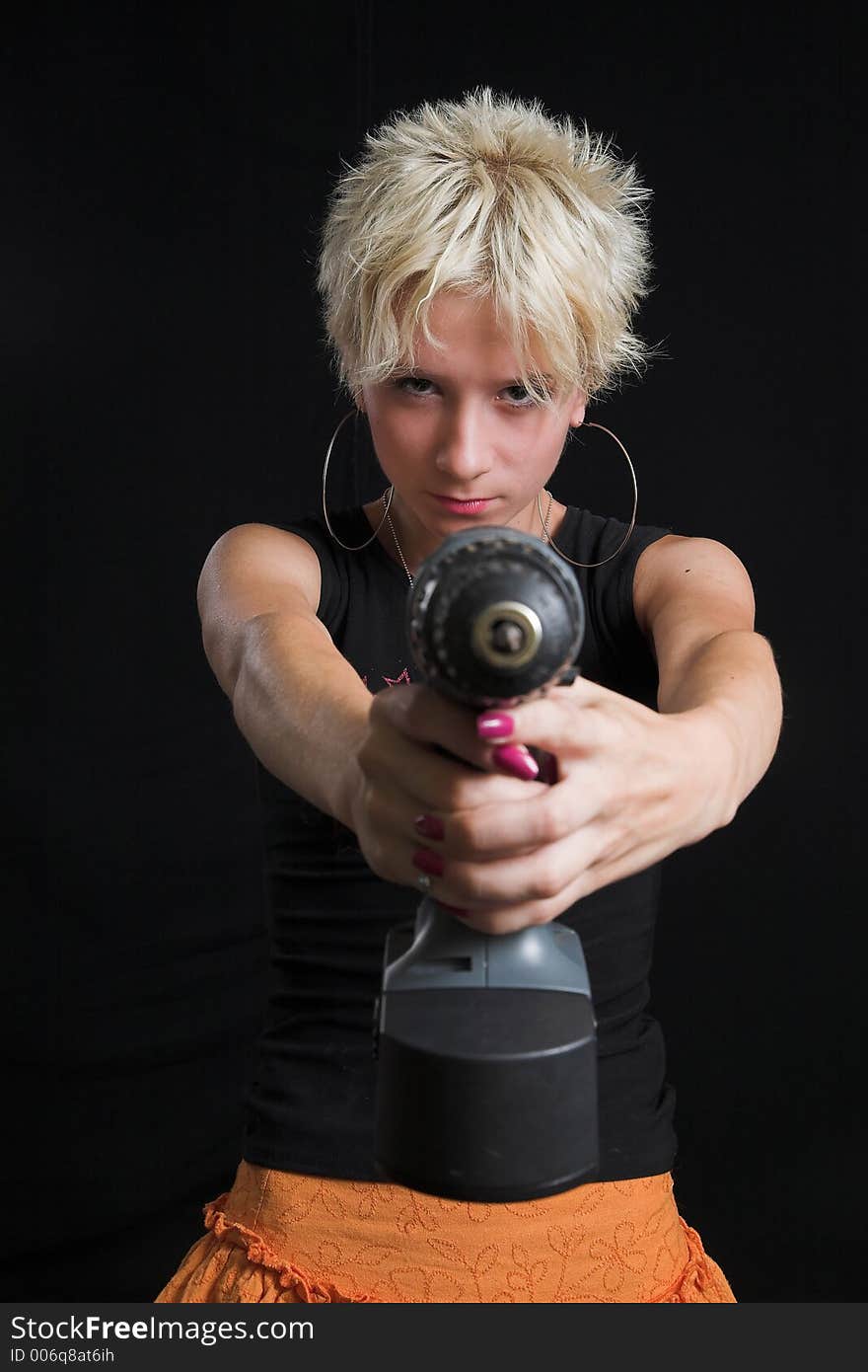 Portrait of beautiful young sexy woman on black background - holding a drill