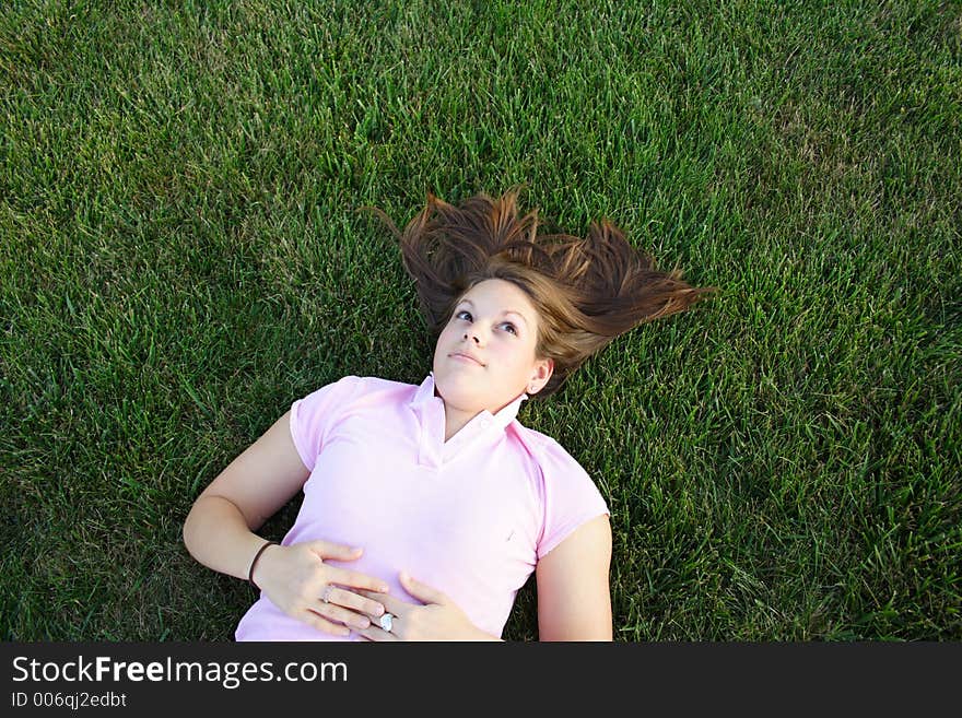 Young woman being silly laying in the grass