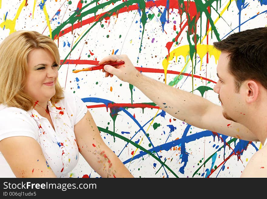 Young casual couple being playful; splashed painted background. Young casual couple being playful; splashed painted background